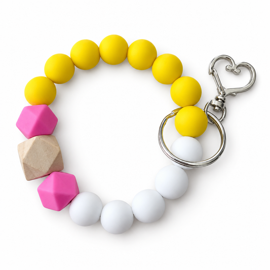 Beaded keychain with yellow, pink, and white beads on a white background